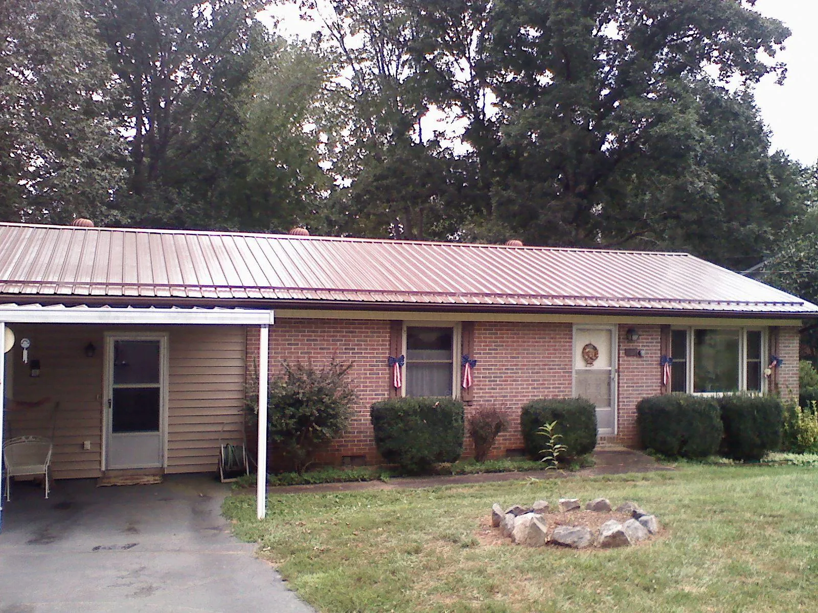 Bronze metal roof and carport on a brick ranch home — Roof Repair work by our crew in Virginia Beach