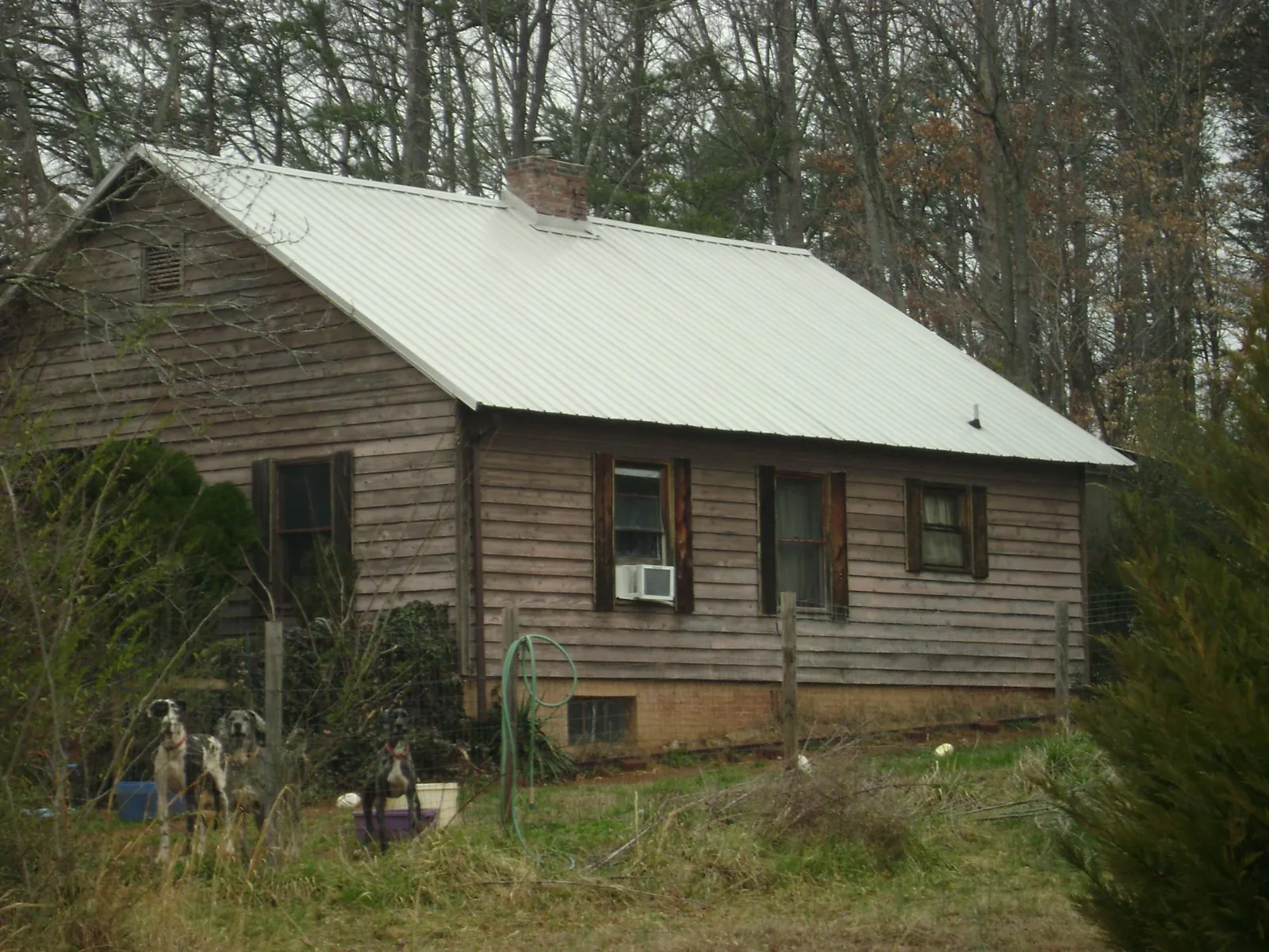 White metal roof on an old wood sided farmhouse, from a Metal Roof Installation job in Virginia Beach